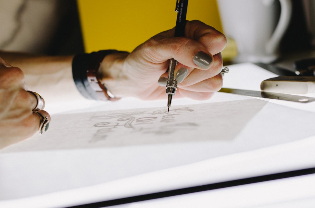 Styling imagery: a designer's hand sketching fine detail at a drawing board